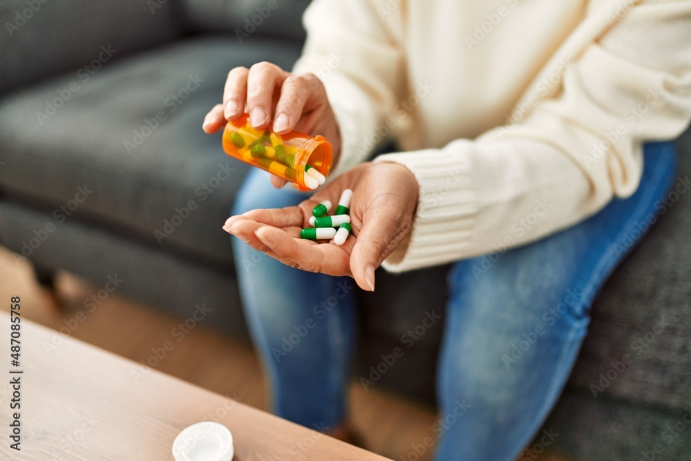 Middle age hispanic woman taking pills at home Middle age hispanic woman taking pills at home