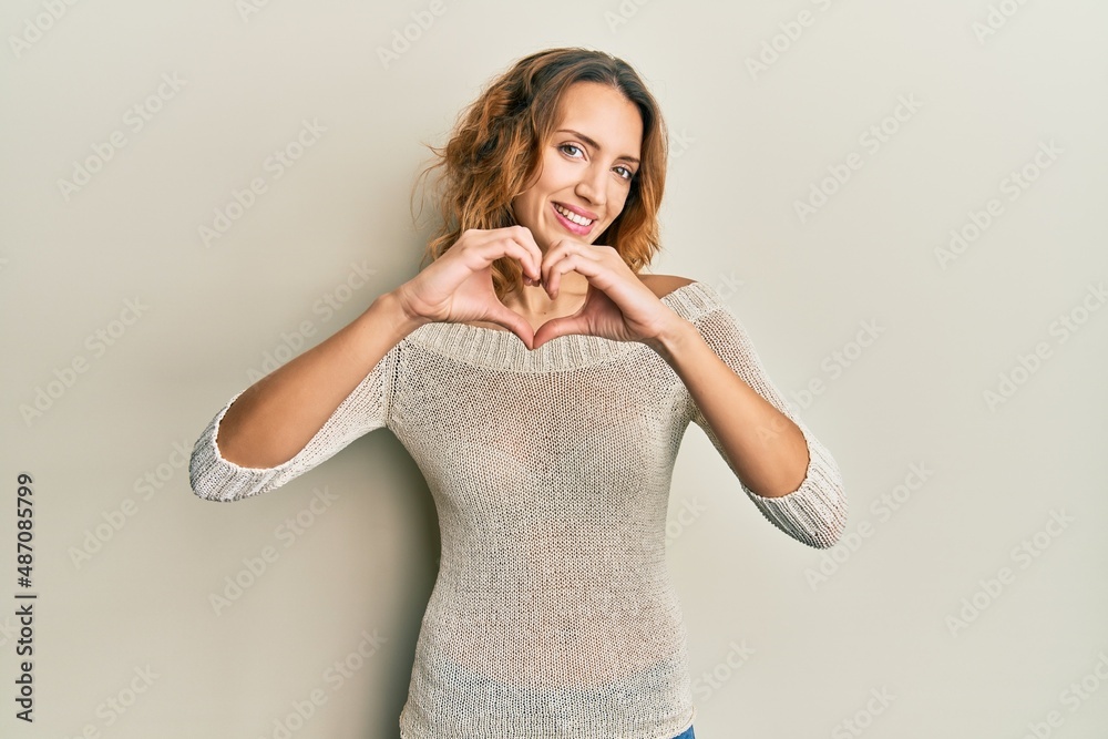 Young caucasian woman wearing casual clothes smiling in love doing heart symbol shape with hands. romantic concept. Young caucasian woman wearing casual clothes smiling in love doing heart symbol shape with hands. romantic concept.