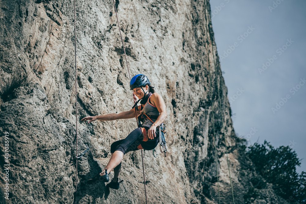 Woman descending a cliff after a hard climb route