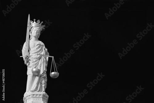 Lady Justice holding balance scales and sword, a 15th century medieval statue at the top of St Mark Basilica in Venice (Black and White with copy space)
