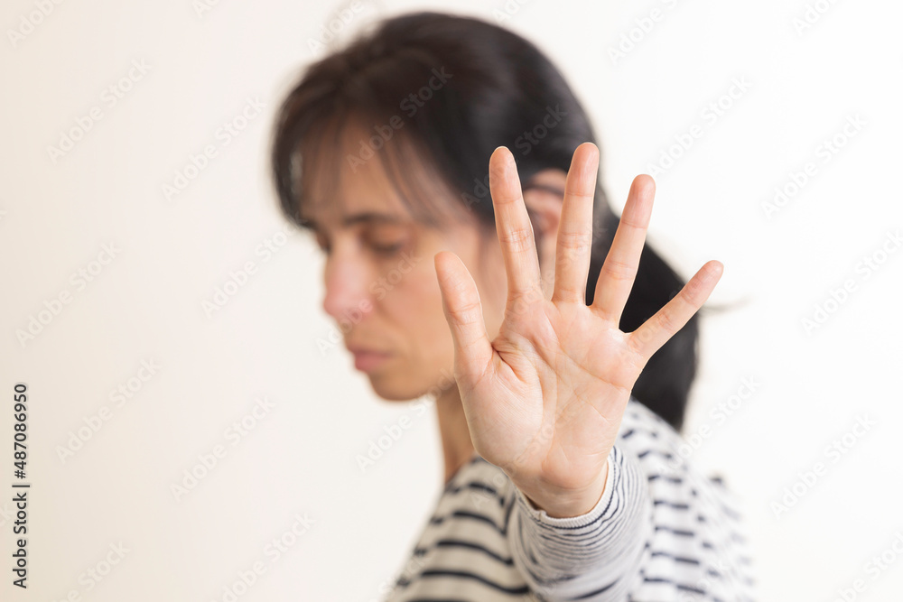 Hand gesture Stop, No. Woman rises her hand up, covering her face and showes stop gesture by hand trying to stop any coming danger. Nonverbal language sign Hand gesture Stop, No. Woman rises her hand up, covering her face and showes stop gesture by hand trying to stop any coming danger. Nonverbal language sign