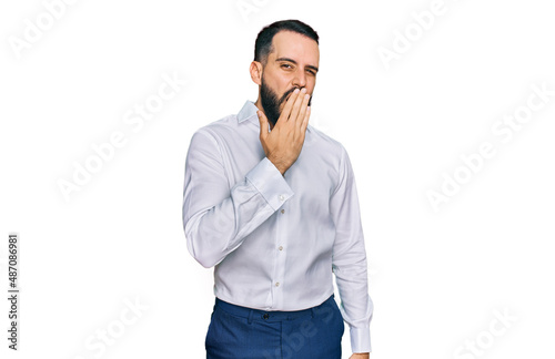Young man with beard wearing business shirt bored yawning tired covering mouth with hand. restless and sleepiness.