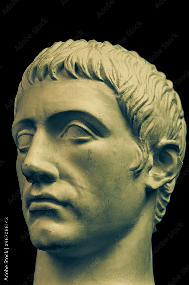 Bronze color gypsum copy of ancient statue of Germanicus Julius Caesar head for artists on black background. Renaissance epoch. Plaster sculpture of man face. Template for art design Bronze color gypsum copy of ancient statue of Germanicus Julius Caesar head for artists on black background. Renaissance epoch. Plaster sculpture of man face. Template for art design