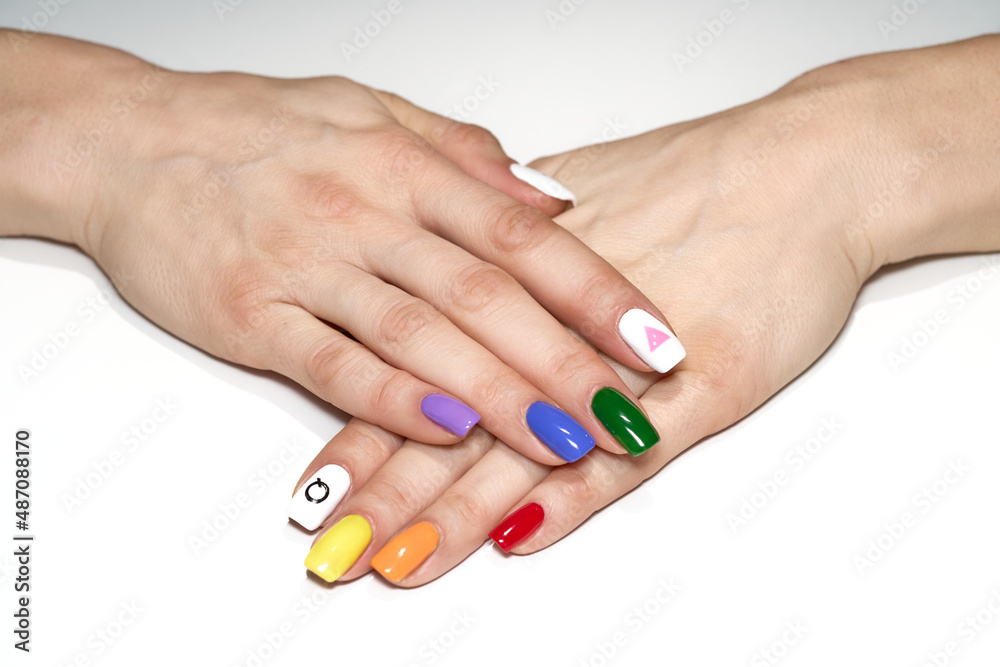 Hands with LGBT rainbow flag and rose triangle manicure. Symbol of lesbian, gay, bisexual, transgender and queer pride isolated on white background. Hands with LGBT rainbow flag and rose triangle manicure. Symbol of lesbian, gay, bisexual, transgender and queer pride isolated on white background.