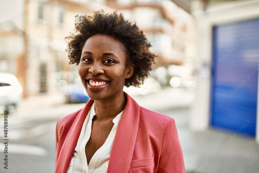 Beautiful business african american woman with afro hair smiling happy and confident outdoors at the city Beautiful business african american woman with afro hair smiling happy and confident outdoors at the city