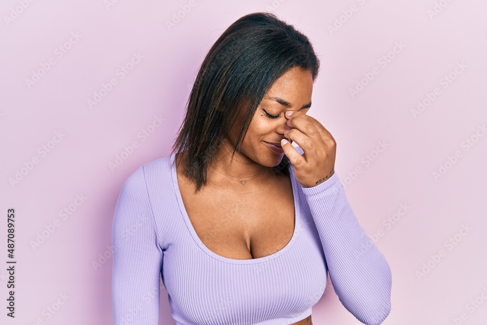 Young african american girl wearing casual clothes tired rubbing nose and eyes feeling fatigue and headache. stress and frustration concept. Young african american girl wearing casual clothes tired rubbing nose and eyes feeling fatigue and headache. stress and frustration concept.