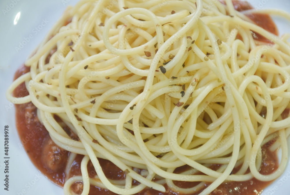 spaghetti dressing fried chop pork and slice tomato in ketchup sauce on plate spaghetti dressing fried chop pork and slice tomato in ketchup sauce on plate