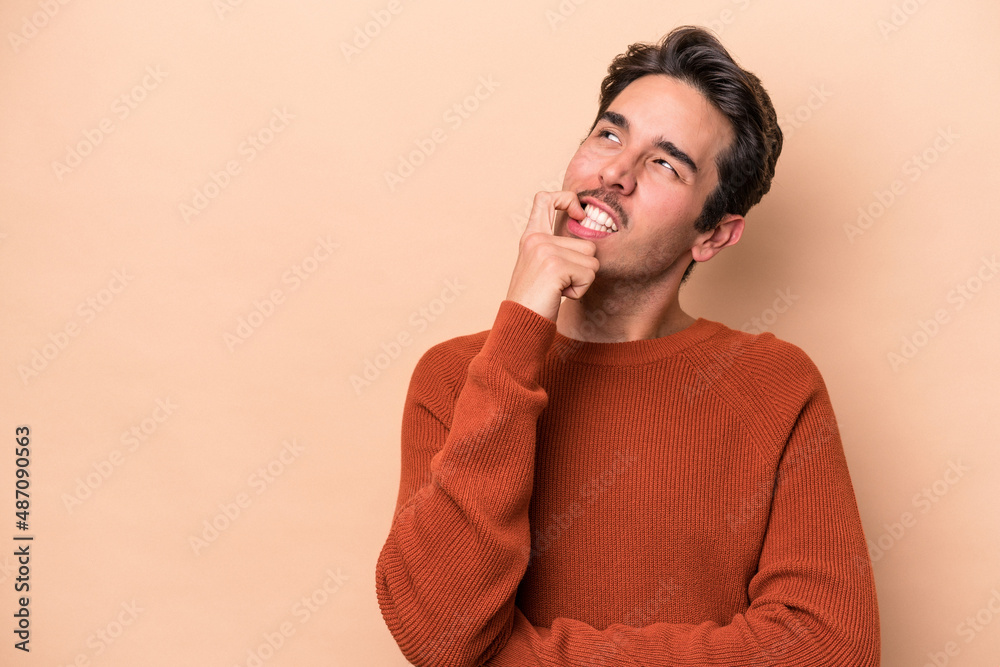 Young caucasian man isolated on beige background looking sideways with doubtful and skeptical expression. Young caucasian man isolated on beige background looking sideways with doubtful and skeptical expression.