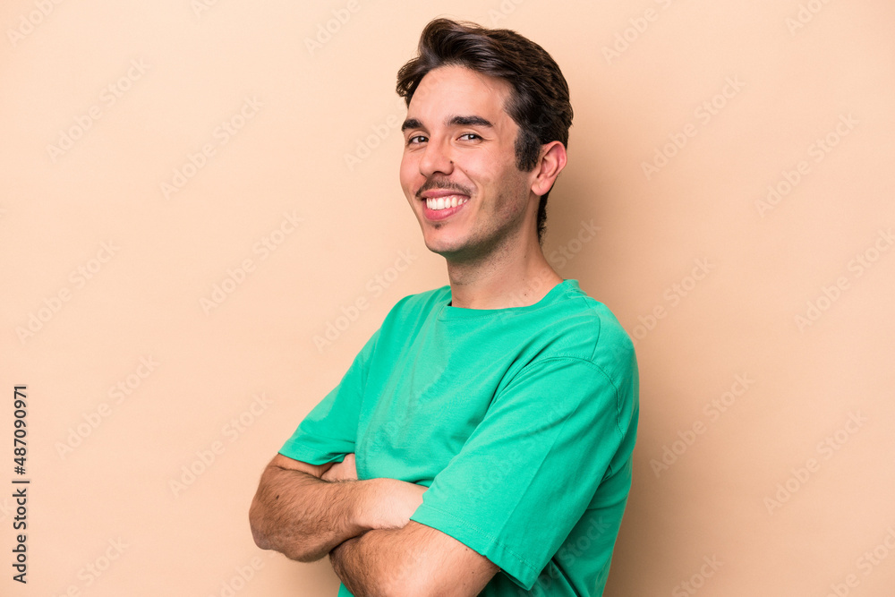 Young caucasian man isolated on beige background happy, smiling and cheerful. Young caucasian man isolated on beige background happy, smiling and cheerful.