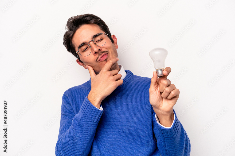 Young caucasian man holding a lightbulb isolated on white background