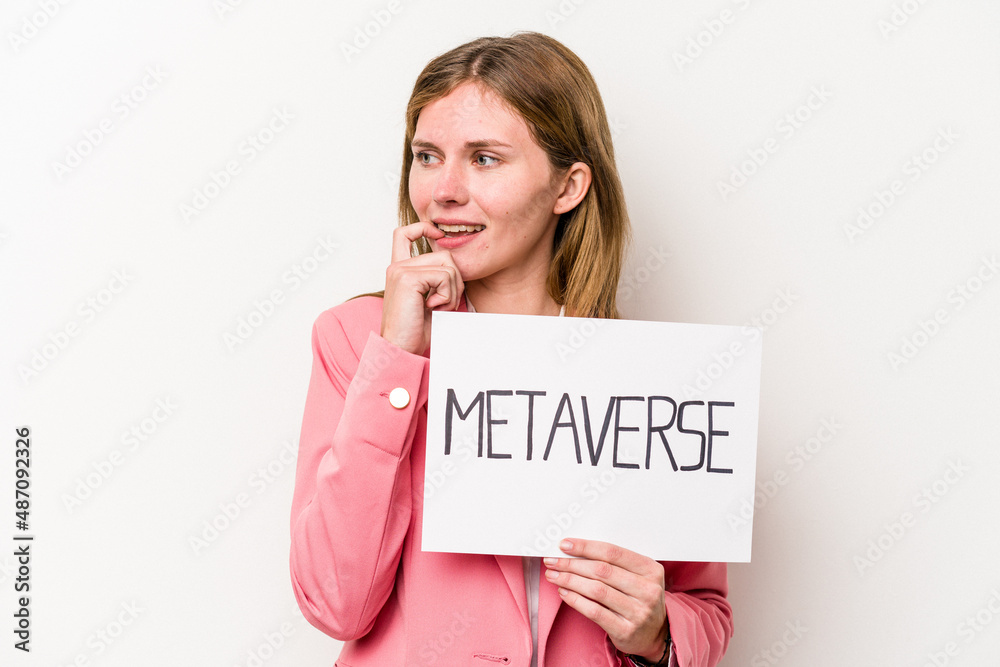 Young English business woman holding a metaverse placard isolated on white background relaxed thinking about something looking at a copy space. Young English business woman holding a metaverse placard isolated on white background relaxed thinking about something looking at a copy space.