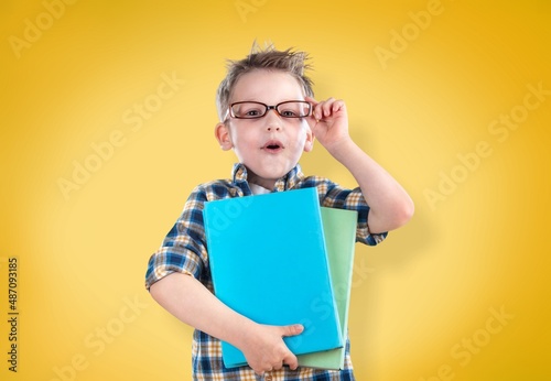 Happy school boy wearing glasses, holding backpack going to school, enjoying studying,