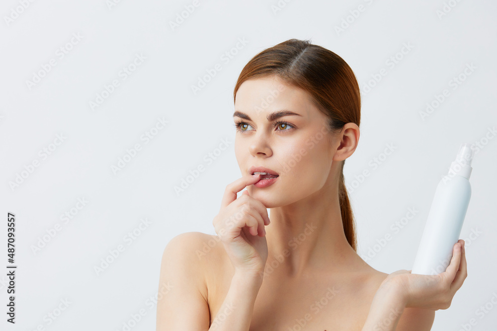 woman skin care lotion with bare shoulders Gray background woman skin care lotion with bare shoulders Gray background
