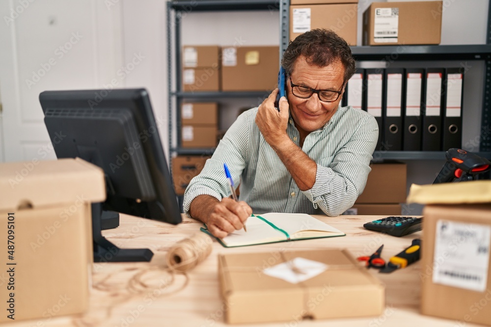 Middle age man ecommerce business worker talking on the smartphone at office Middle age man ecommerce business worker talking on the smartphone at office