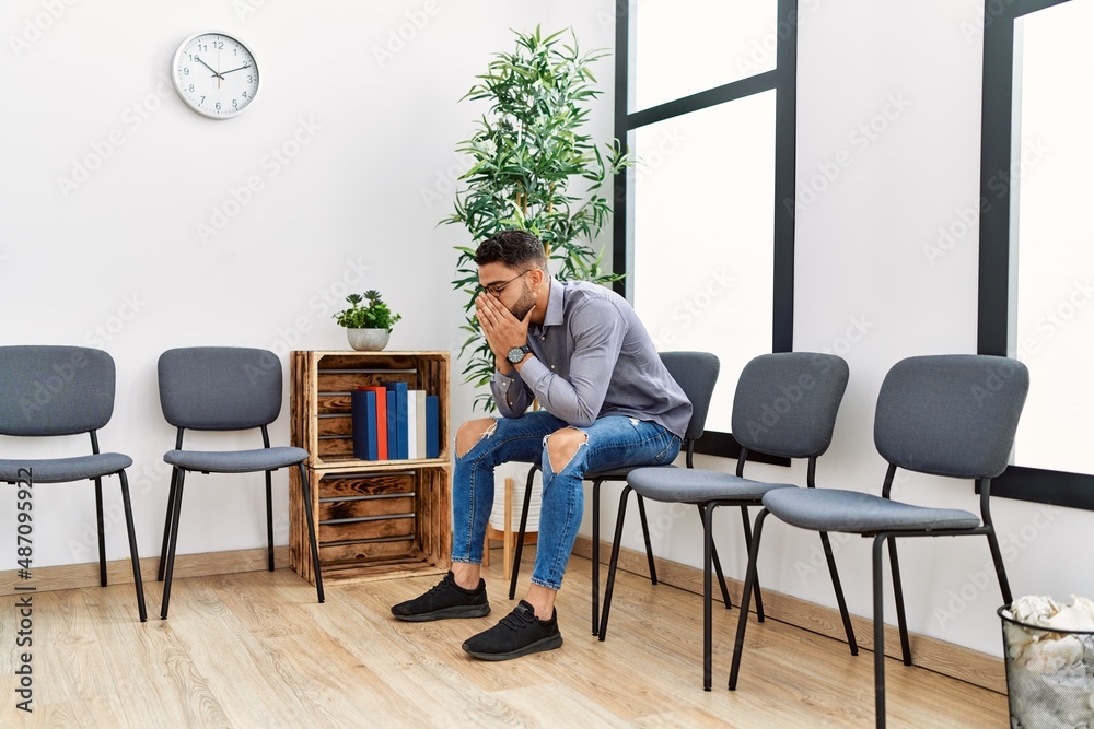 Young arab man desperate sitting on chair at waiting room