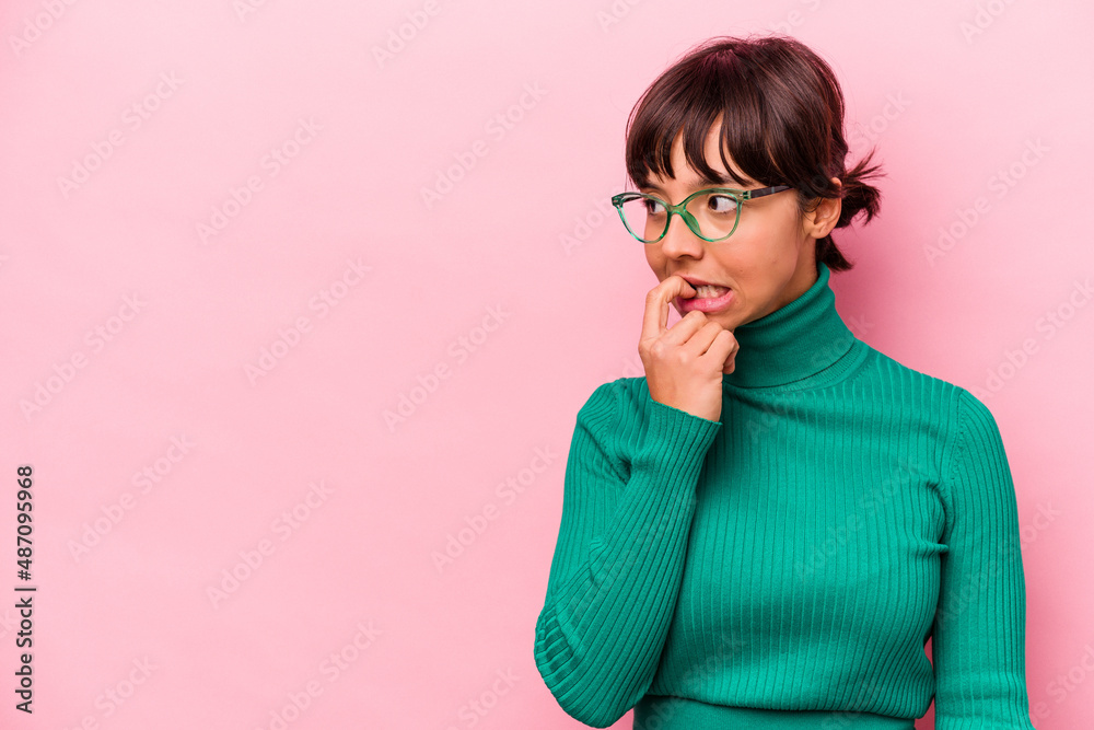 Young hispanic woman isolated on pink background relaxed thinking about something looking at a copy space. Young hispanic woman isolated on pink background relaxed thinking about something looking at a copy space.