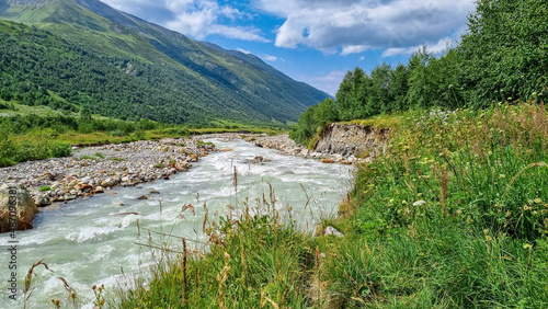 Patara Enguri River flowing down the a valley in the Greater Caucasus Mountain Range in Georgia  Svaneti Region  Ushguli. The source of the river is the Shkhara Glacier. Melting water. Highlands.