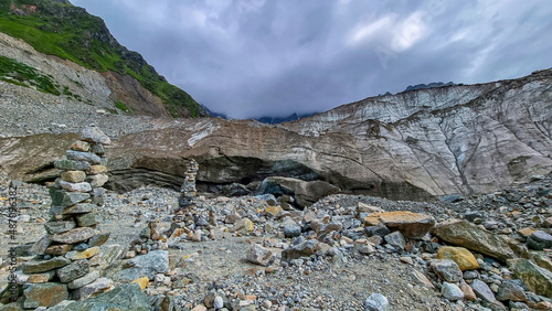 Stacked stones in front of the Shkhara Glacier in the Greater Caucasus Mountain Range in Georgia, Svaneti Region, Ushguli. Wanderlust, Stone cairns. Freedom. Glacier melting. Patara enguri river.