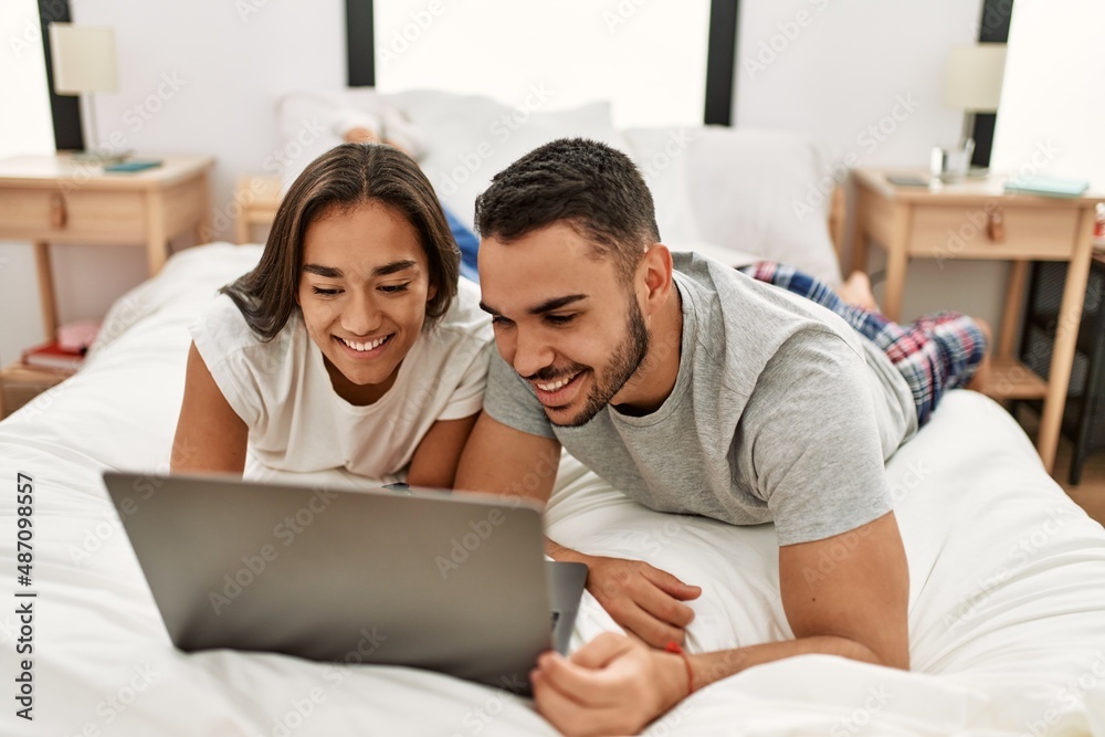 Young latin couple smiling happy using laptop at bedroom Young latin couple smiling happy using laptop at bedroom