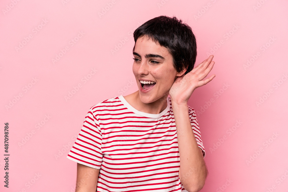 Young caucasian woman isolated on pink background trying to listening a gossip. Young caucasian woman isolated on pink background trying to listening a gossip.