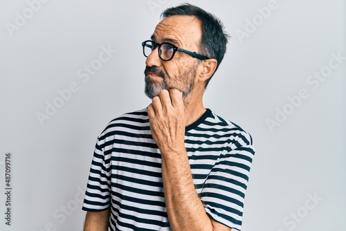 Middle age hispanic man wearing casual clothes and glasses thinking concentrated about doubt with finger on chin and looking up wondering