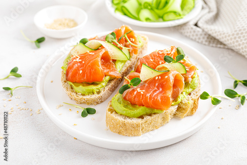 Open sandwiches with salted salmon, guacamole avocado and microgreens. Seafood. Healthy food.