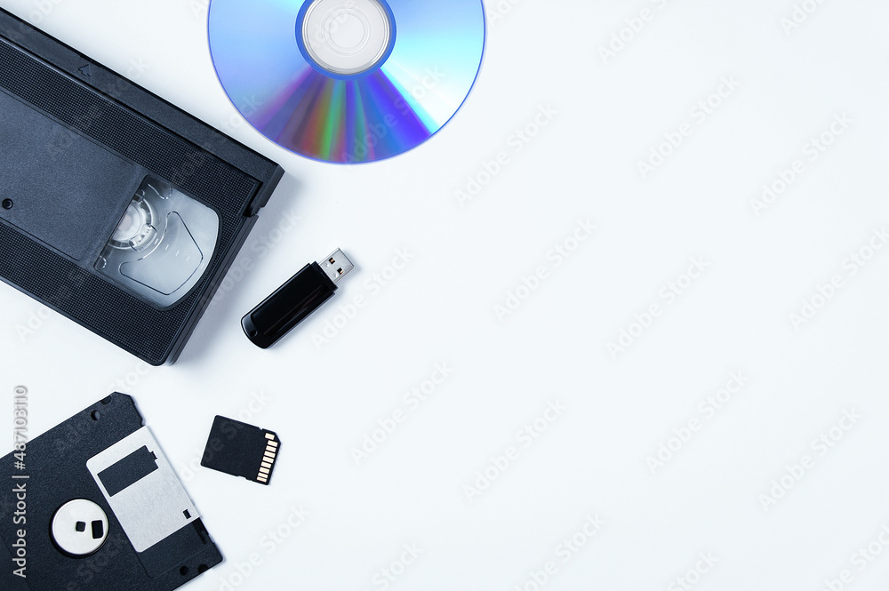 Video cassette, flash drive, memory card, CD, floppy disk. White background. Place text. Video cassette, flash drive, memory card, CD, floppy disk. White background. Place text.