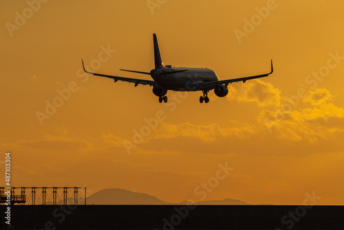 夕焼けの山口宇部空港に着陸するジェット旅客機