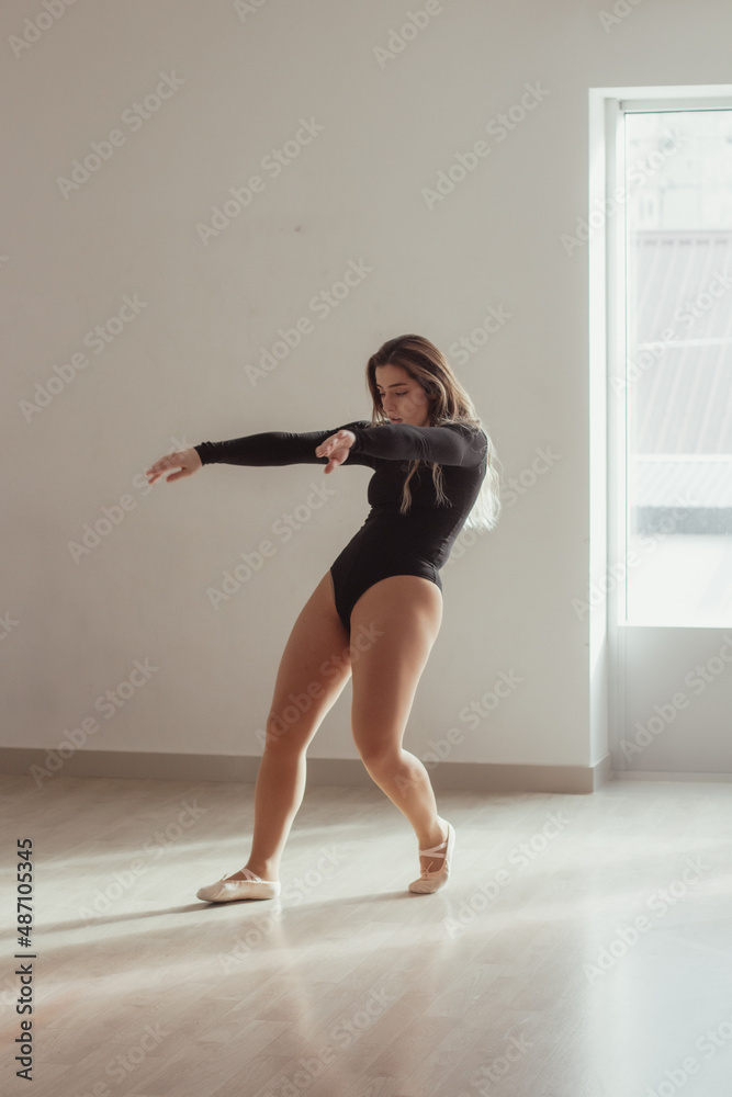 Obraz premium A woman standing in a dance pose in a dance studio, dressed in a dance outfit.