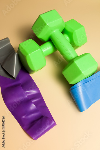 Weights for sports and elastic bands on a nude background  sports health