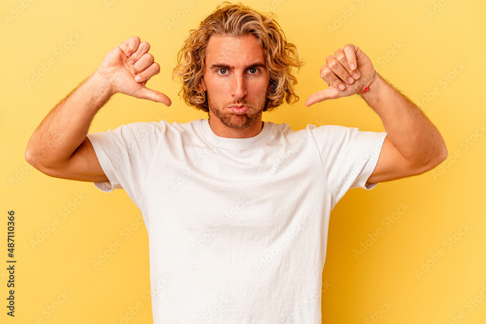 Young caucasian man isolated on yellow background showing a dislike gesture, thumbs down. Disagreement concept. Young caucasian man isolated on yellow background showing a dislike gesture, thumbs down. Disagreement concept.