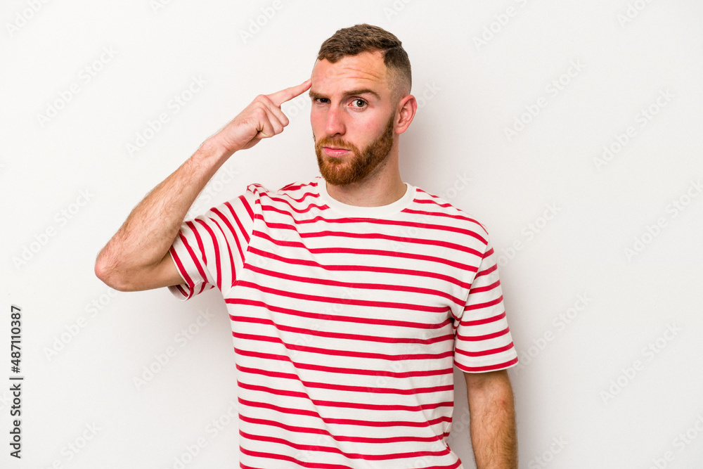 Fototapeta premium Young caucasian man isolated on white background pointing temple with finger, thinking, focused on a task.
