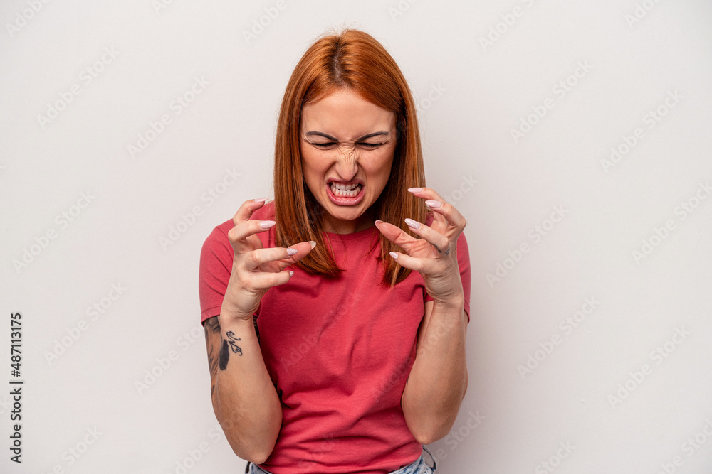 Young caucasian woman isolated on white background upset screaming with tense hands. Young caucasian woman isolated on white background upset screaming with tense hands.