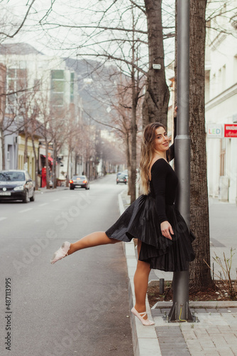 A woman standing on the pavement in a dancing outfit, looking into the camera.  © Esma