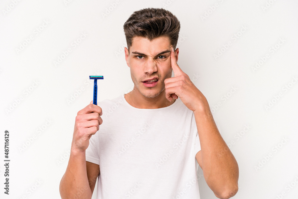 Young caucasian man shaving his beard isolated on white background showing a disappointment gesture with forefinger. Young caucasian man shaving his beard isolated on white background showing a disappointment gesture with forefinger.