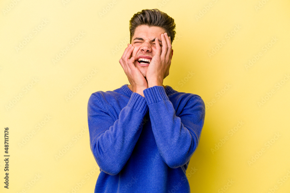 Young caucasian man isolated on yellow background whining and crying disconsolately.