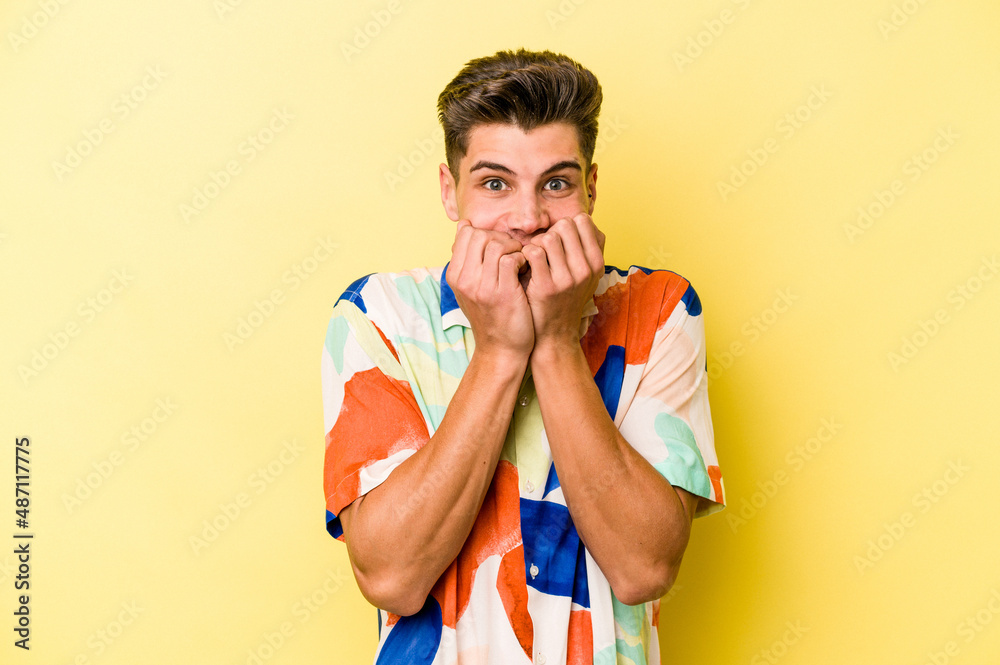 Young caucasian man isolated on yellow background biting fingernails, nervous and very anxious. Young caucasian man isolated on yellow background biting fingernails, nervous and very anxious.