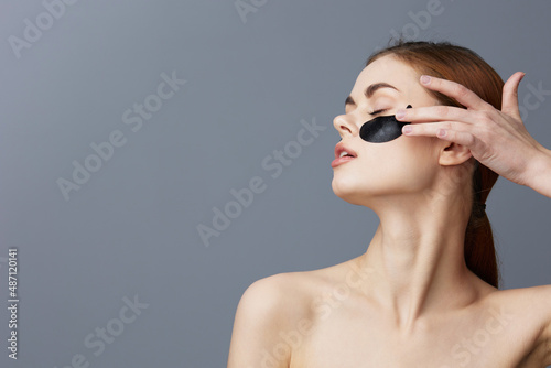 Fotobehang beautiful woman eye patches on face bare shoulders skin care Gray background