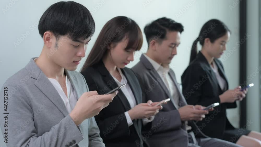 Group of Asian businessman and businesswoman watching smart mobile phones, Startup business teenagers using social media in the office, Social addict concept Group of Asian businessman and businesswoman watching smart mobile phones, Startup business teenagers using social media in the office, Social addict concept