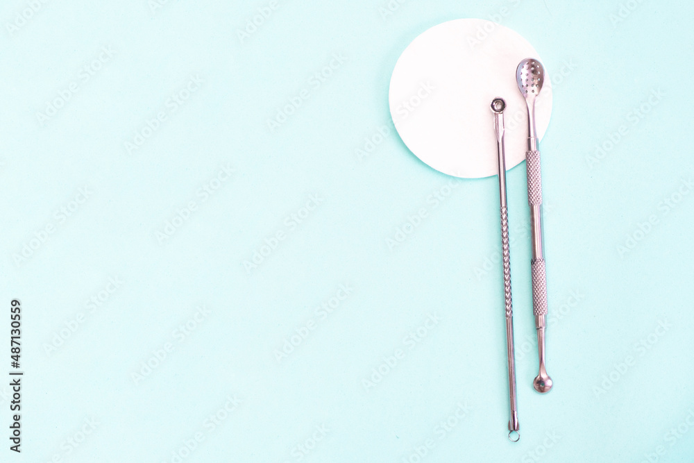 uno spoon for cleansing the face is on a soft turquoise background. flat lay, cosmetology and tools uno spoon for cleansing the face is on a soft turquoise background. flat lay, cosmetology and tools