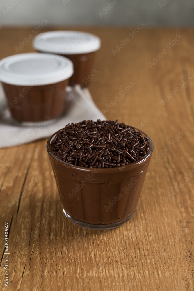 Brazillian chocolate sweet called Brigadeiro in pot on wooden desk background. Vegan version Brazillian chocolate sweet called Brigadeiro in pot on wooden desk background. Vegan version