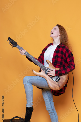 young girl with a guitar on an orange background