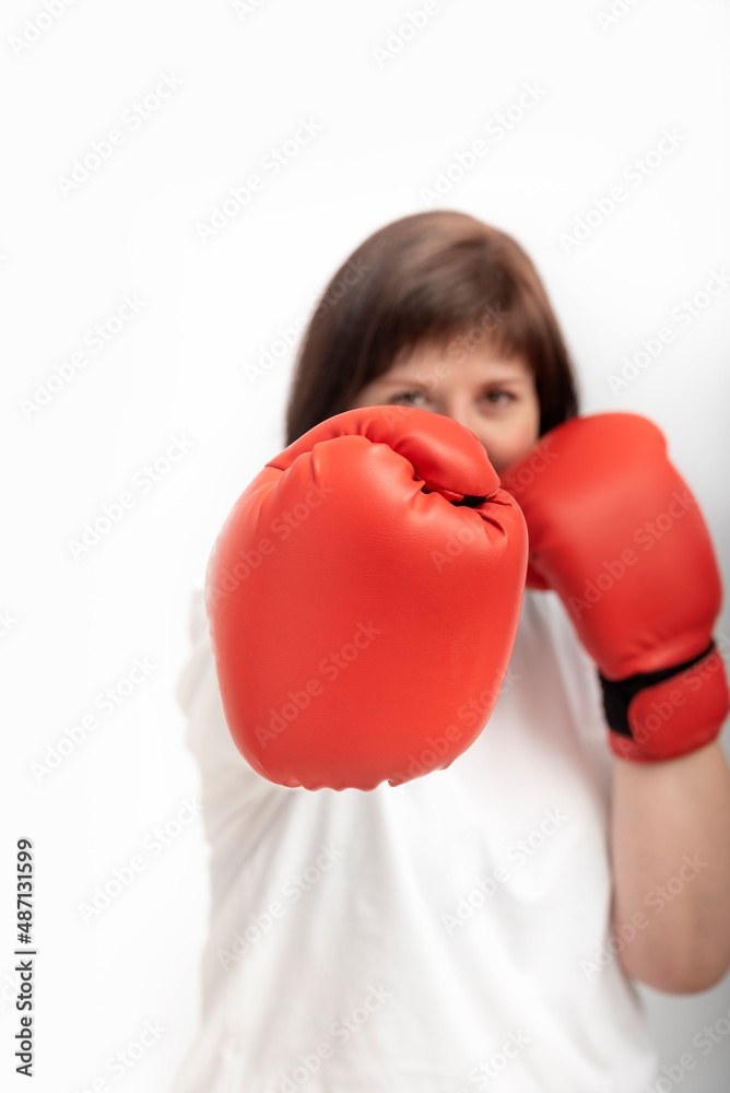 Portrait of young confident woman in boxing gloves on white background. Feminism and womens rights. Portrait of young confident woman in boxing gloves on white background. Feminism and womens rights.