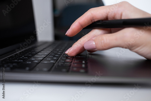 Woman typing on laptop keyboard, office worker