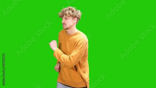 cheerful and handsome guy dancing on green screen.