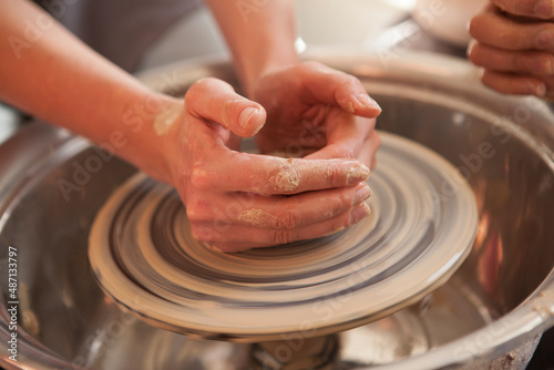 Close up of female hands working on pottery wheel