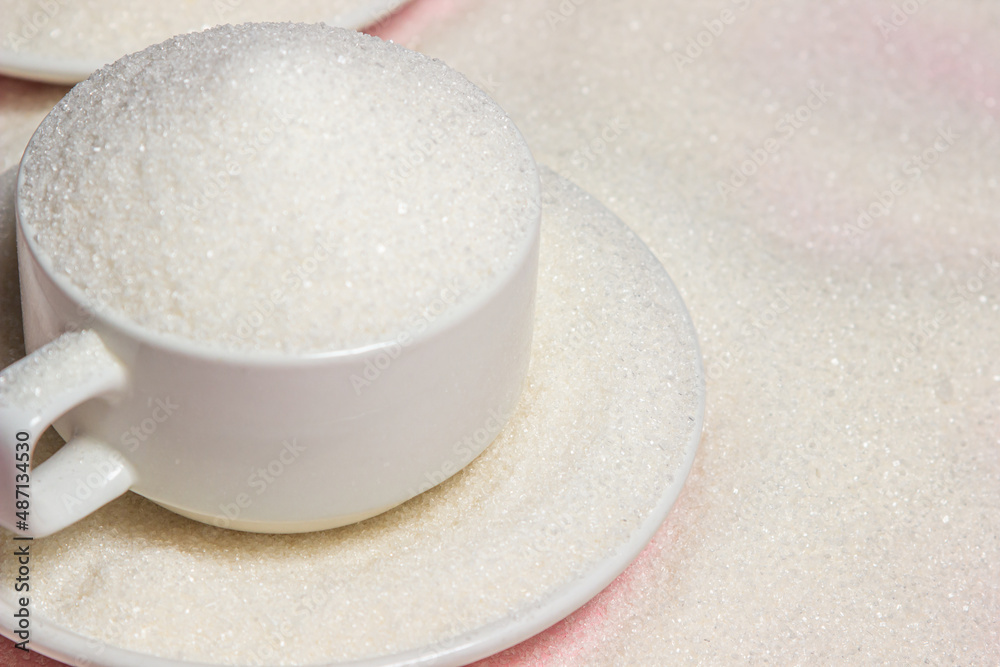 Overflowing cups with sugar on a pink background. Excessive sugar intake Overflowing cups with sugar on a pink background. Excessive sugar intake