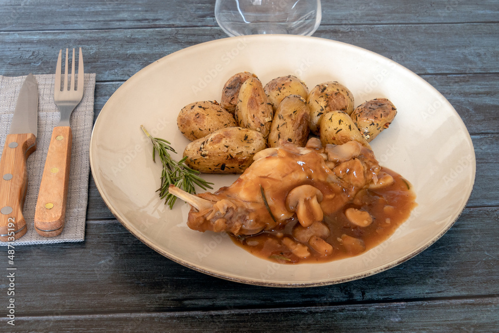 new potatoes with mushroom rabbit in a plate on a gray background new potatoes with mushroom rabbit in a plate on a gray background