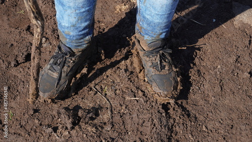 Women boots in the mud, detail of dirty boots and muddy, walk. Top down dirty black laced boots woman in blue jeans.