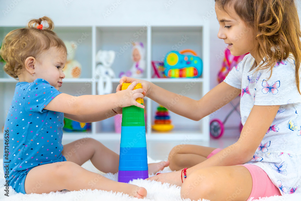 Fototapeta premium A baby child plays with toys in the playroom. Selective focus.